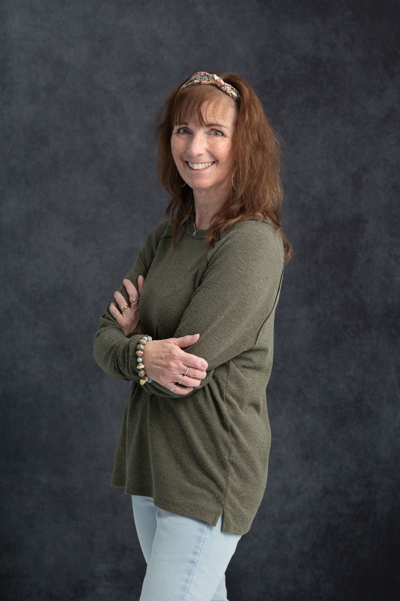 woman in green sweatshirt and jeans in photo studio